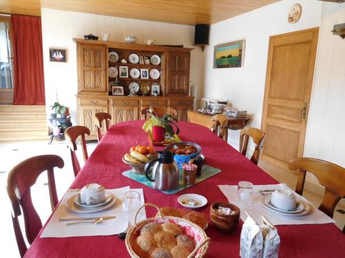 une table avec un tissu de table rouge et de la nourriture dans l'établissement la forge, à Lanty-sur-Aube