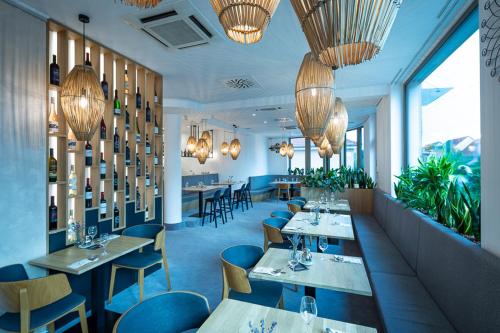 restauracja ze stołami, krzesłami i żyrandolami w obiekcie Fine Restaurant & Apartments w mieście Malacky