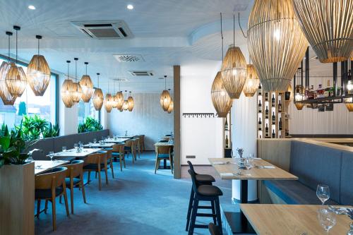 a dining room with tables and chairs and chandeliers at Fine Restaurant & Apartments in Malacky