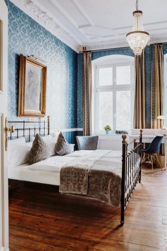 a bedroom with a large bed with blue walls at Honigmond Boutique Hotel in Berlin