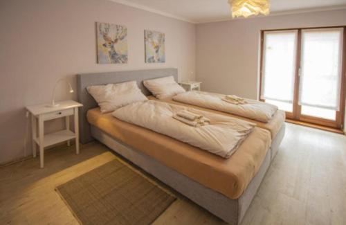 a bedroom with a large bed with white sheets and a window at Ferienwohnung Habermehl in Oppenau