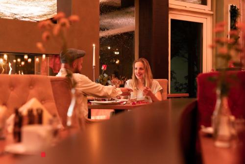 a man and woman sitting at a table in a restaurant at Trihotel Rostock - Wellnesshotel Adults Only in Rostock