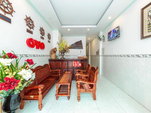 sala de estar con mesa, sillas y flores en OYO 828 Hoa Giay Hotel, en Nha Trang