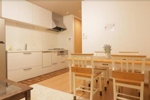 a kitchen with white cabinets and a wooden table at Cozy enjoyment hotel no.29 in Kyoto