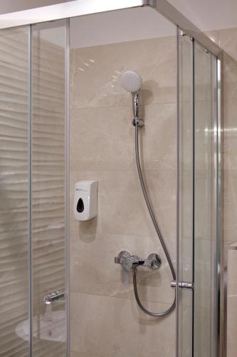 a shower with a shower head in a bathroom at Relax Panzió in Győr
