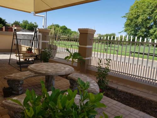 a patio with a table and a bench and a fence at Tehillah Guesthouse in Upington