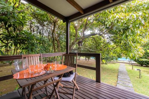 a wooden deck with a table and chairs on it at Casa das Clivias in Ponta Delgada