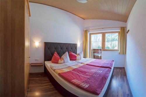 a bedroom with a large bed with a large window at Landhaus Volderau in Neustift im Stubaital