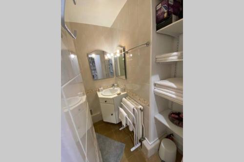 W białej łazience znajduje się umywalka i lustro. w obiekcie Le Jeu de Paume à Beaune centre w mieście Beaune