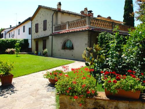 uma casa com flores em frente a um quintal em Holiday Home Capanna di Sotto by Interhome em Villa Bertolli