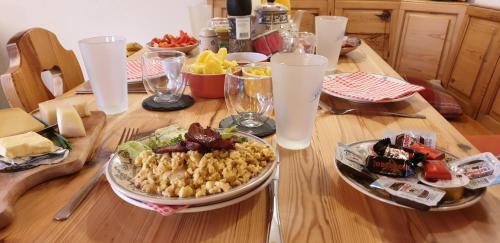 a wooden table with a plate of food on it at Ferienhaus & Ferienwohnung Wiñay Wayna Gotschna Blick Klosters in Klosters Serneus