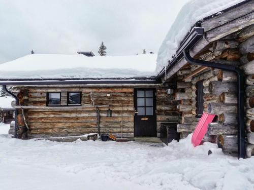 ルオストにあるHoliday Home Hopukka a2 by Interhomeのピンクのドアが付いた雪の中のログキャビン