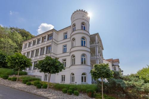 un grand bâtiment blanc avec des arbres devant lui dans l'établissement Ferienwohnung Sonnenseite, à Sellin