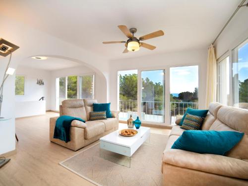 ein Wohnzimmer mit Sofas und einem Deckenventilator in der Unterkunft Holiday Home Nelli by Interhome in Calpe