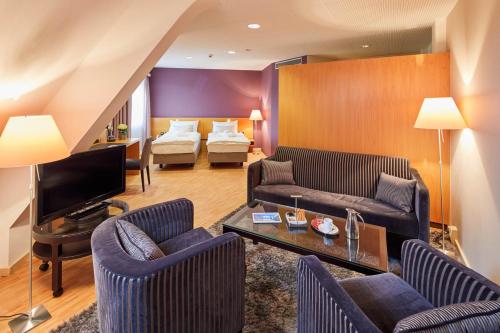 a living room with two couches and a television at Hotel Banana City Winterthur in Winterthur