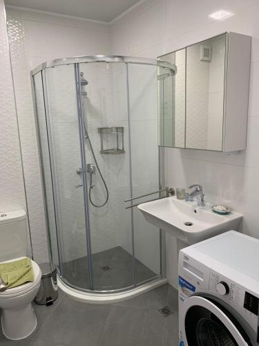 a bathroom with a shower and a toilet and a sink at Summer Apartments Kabakum by Flat Manаger in Golden Sands