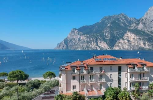 a hotel with a view of the water and mountains at Hotel Baia Azzurra - Lake Front in Nago-Torbole