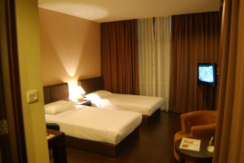 a hotel room with two beds and a television at Manja Hotel in Kota Kinabalu