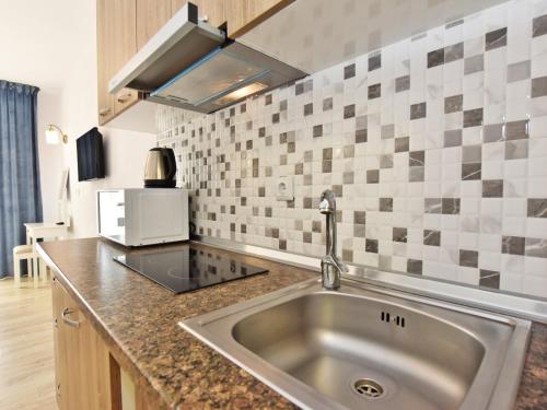 una cucina con lavandino e forno a microonde di Azur Apartments - Nikiti Halkidiki a Nikiti