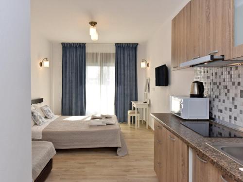 una cucina e un soggiorno con un letto in una camera di Azur Apartments - Nikiti Halkidiki a Nikiti