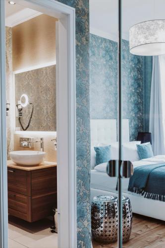 a bedroom with a bed and a sink and a mirror at THE GATE GARDEN Hotel in Berlin