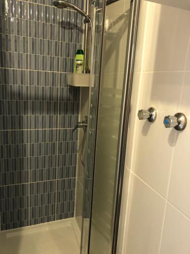 a shower with a glass door with a bottle on a shelf at Apartamento Trinidad mit Netflix in Fuengirola