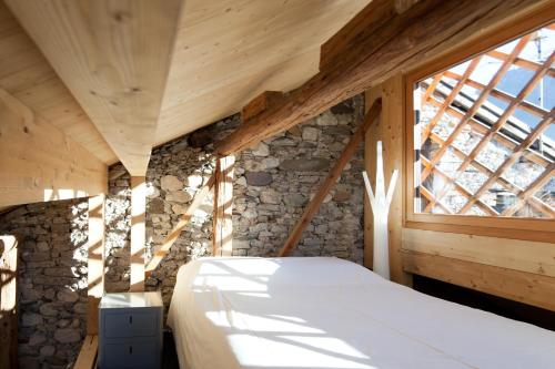 a bedroom with a large window in a wooden house at Mansarda in Centro in Fiera di Primiero
