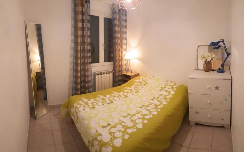 - une chambre avec un lit jaune orné de fleurs dans l'établissement Cosy Room in the centre, à Saint-Laurent-du-Var