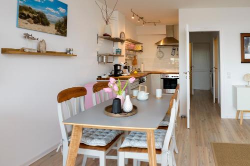 eine Küche und ein Esszimmer mit einem Tisch und Stühlen in der Unterkunft Ankerplatz 57 in Neustadt in Holstein