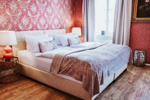 a bedroom with a large bed with a red wall at THE GATE GARDEN Hotel in Berlin