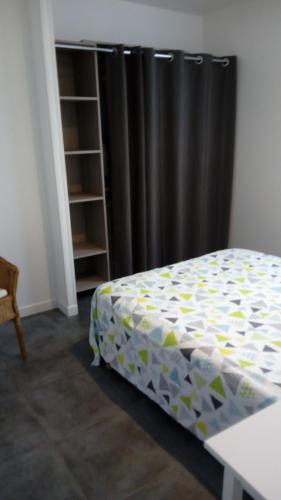 a bedroom with a bed and a black curtain at les tilleuls in Léon