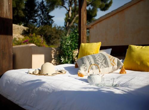 Una cama con sombreros y sombreros y gafas. en Villa Can Moya, en Palma de Mallorca