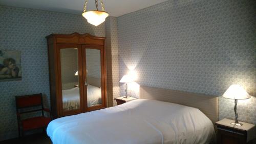 a bedroom with a white bed and a mirror at Les Vergnes in Saint-Pardoux-le-Neuf