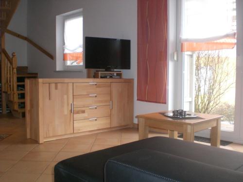 a living room with a television on a wooden cabinet at Ferienanlage Karolinenhof 2 in Haundorf