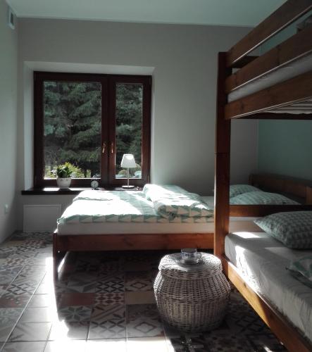 a bedroom with two beds and a window at Apartamenty Leszczynowa 7 blisko Zatora in Spytkowice