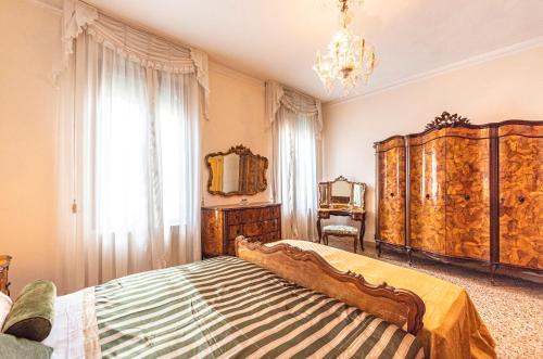 sypialnia z dużym łóżkiem i żyrandolem w obiekcie CASA VESCOVO, free Wi-Fi near San Marco Square w Wenecji