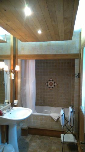 a bathroom with a sink and a tub and a sink at Les Vergnes in Saint-Pardoux-le-Neuf