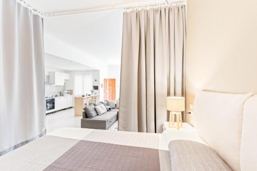 1 dormitorio blanco con 1 cama y sala de estar en Luminoso Nuovalucello Apart- Giardino e Parcheggio privato, en Catania