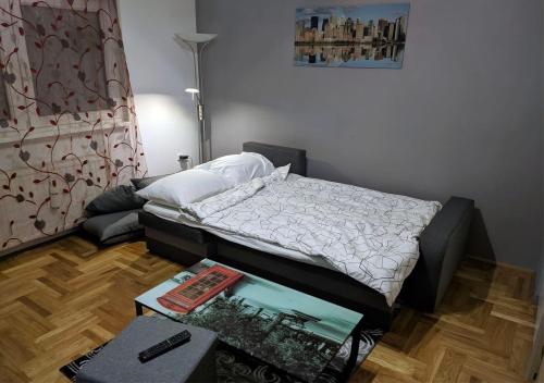 a bedroom with a bed and a table with a book at Apartment in quiet area with free parking in Varaždin