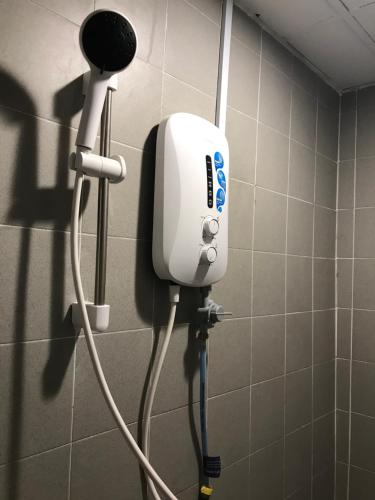 a blow dryer in a shower in a bathroom at Nusantara Mattwaddien Hostel in Kota Kinabalu