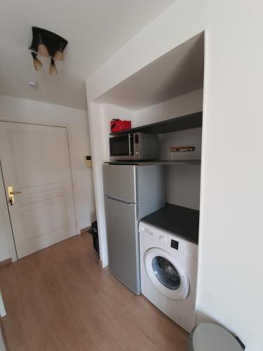 une cuisine avec un lave-linge et un micro-ondes dans l'établissement Studio Royale Marine, à Fréjus