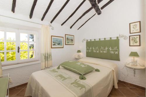 1 dormitorio con cama y pizarra en la pared en Villa La Liccia Misia, en Santa Teresa Gallura