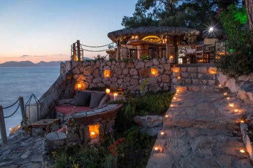 a stone building with a bench and lights on it at Perdue Hotel in Faralya
