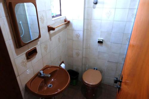 La petite salle de bains est pourvue d'un lavabo et de toilettes. dans l'établissement Hotel Almanara Cuiabá-Mato Grosso-Brasil, à Cuiabá