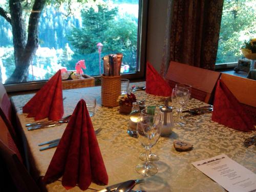 a table with red napkins and wine glasses on it at Hotel Villa Emilia in Ortisei