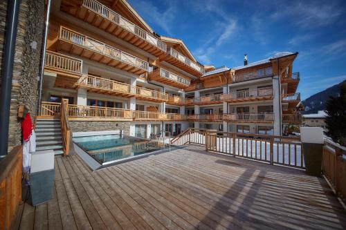a building with a deck and a swimming pool at AlpenParks Hotel & Apartment Sonnleiten in Saalbach Hinterglemm