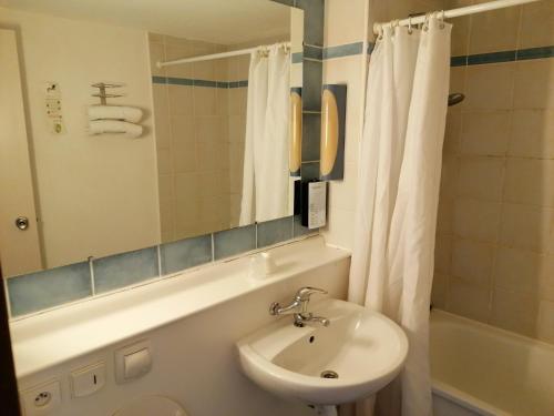 a bathroom with a sink and a toilet and a mirror at Campanile Perpignan Sud in Perpignan