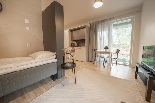 a room with a bed and a table and a television at Spot Apartments Hiekkaharju in Vantaa