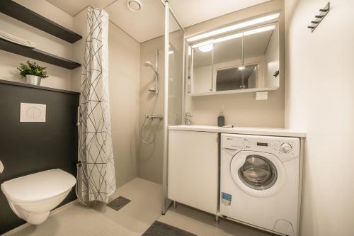 a bathroom with a toilet and a washing machine at Spot Apartments Hiekkaharju in Vantaa