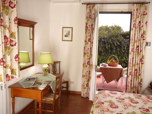 1 dormitorio con escritorio, 1 cama y ventana en Agriturismo Limoneto en Case Monterosso